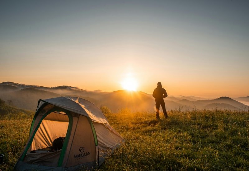 Dome tent pitched on a mountain ridge at sunrise